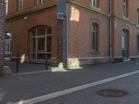 a picture of a street next to a red brick building that is built into the side of a hill