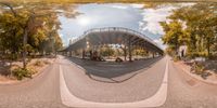 fish - eye view of the bridge across from the street, with cars driving underneath it