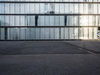 empty street with buildings and sky reflected in windows behind them in front of an airport