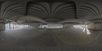 a fisheye picture of an empty building from inside it and the floor is covered in circles