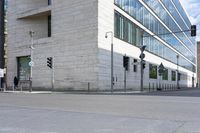 a red fire hydrant in front of an office building with glass windows and street lights