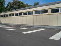 a metal building with a corrugated door in front of it and trees lining the street behind it