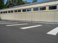 a metal building with a corrugated door in front of it and trees lining the street behind it