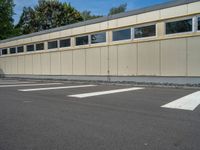 a metal building with a corrugated door in front of it and trees lining the street behind it