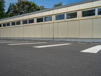 a metal building with a corrugated door in front of it and trees lining the street behind it