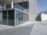 an empty office building with glass walls on the outside and stairs leading up to it