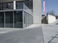 an empty office building with glass walls on the outside and stairs leading up to it