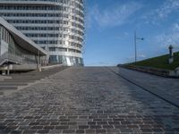 a paved brick walkway on a hill near large buildings in the city of oslo, norway