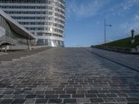 a paved brick walkway on a hill near large buildings in the city of oslo, norway