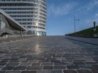 a paved brick walkway on a hill near large buildings in the city of oslo, norway