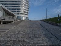 a paved brick walkway on a hill near large buildings in the city of oslo, norway