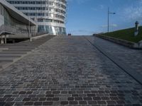 a paved brick walkway on a hill near large buildings in the city of oslo, norway