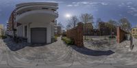 360 - view of two buildings with multiple parking spaces in them on the bricked street