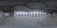 a 360 - camera picture of an empty building on the outside, a sky view is shown through the window