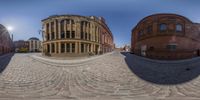 the 360 - view is reflecting the building at the intersection of a street and sidewalk