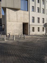 a person with a suitcase walking across an outside courtyard in front of a building,