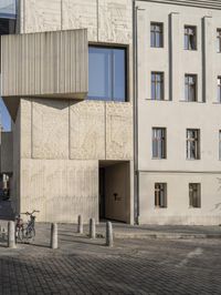 a person with a suitcase walking across an outside courtyard in front of a building,