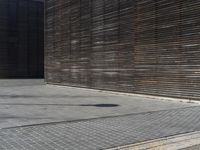 the man rides down the sidewalk on a skateboard in his red coat in front of a building