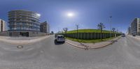 street view of buildings from a 360 - fisheye camera angle, in the foreground, on a sunny day