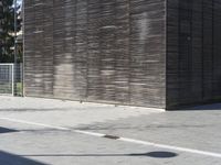 a man on a skateboard is leaning against a wall that is behind him and facing the other direction