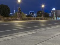 two motorcycles parked on the side of a street at night time and a pedestrian is visible