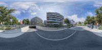 a distorted fisheye view of a street from below of skateboarding ramps, and buildings