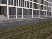 this is an empty sidewalk in front of a building with closed doors and blinds on it