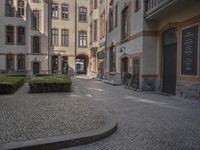 the two bicycles are parked next to each other outside the house, with cobblestone walkway going by the building