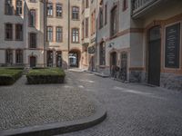 the two bicycles are parked next to each other outside the house, with cobblestone walkway going by the building