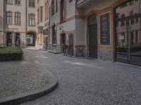 the two bicycles are parked next to each other outside the house, with cobblestone walkway going by the building