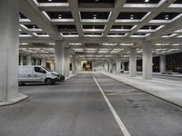 the cars are parked in the big parking garage area alone in the daylight at the time