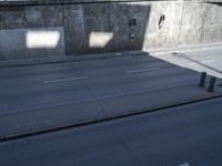 a city street that has some poles near the curb in front of it on the sidewalk