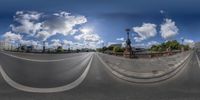 the sky is filled with a few clouds over a street with white lines in the foreground