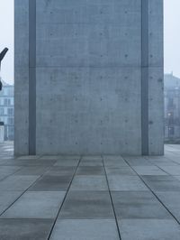 two chairs are located against the stone pillars at the top of a building with a sky view