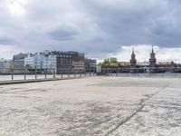 an empty parking lot with buildings in the background and buildings behind it on a sunny day