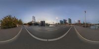 a skateboarder is seen on a curved ramp in a city with a bridge and buildings