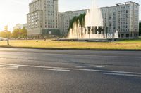 a traffic light is on and there is a large building with many windows and fountains