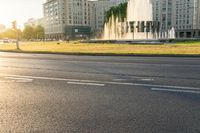 a traffic light is on and there is a large building with many windows and fountains