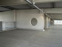 an empty parking garage with metal flooring and large circular window in center of room