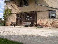 an open wooden door on an old building outside with a bench and wagon attached to it