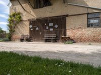 an open wooden door on an old building outside with a bench and wagon attached to it