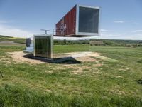 a large container house in a field with no roof and windows that are standing in the grass