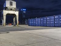 an image of a group of blue container structures in a city setting on a dark sky