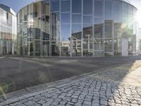 the fire hydrant is parked on the sidewalk near a building with glass walls and windows