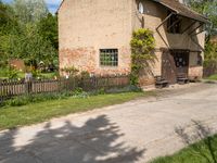 a house with a long wooden driveway in front of it and a fence around the entrance