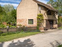 a house with a long wooden driveway in front of it and a fence around the entrance