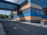 the street outside of a large modern building with colorful facades and windows that are made from steel