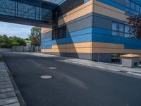 the street outside of a large modern building with colorful facades and windows that are made from steel