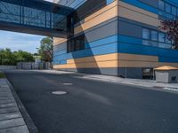 the street outside of a large modern building with colorful facades and windows that are made from steel