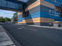 the street outside of a large modern building with colorful facades and windows that are made from steel